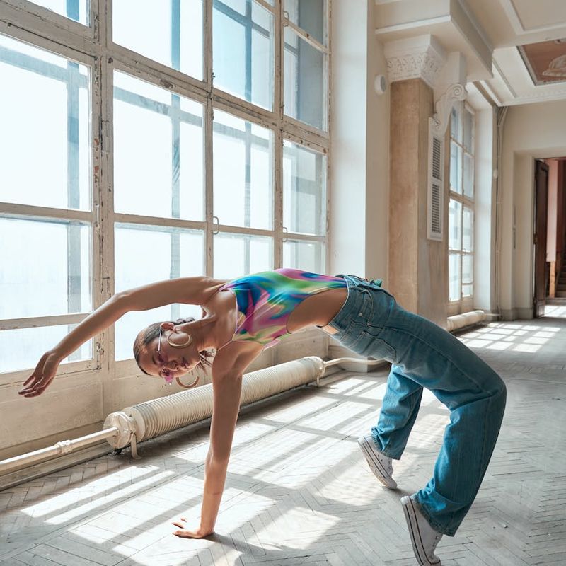 Person performing a dynamic cardio movement in a spacious studio.